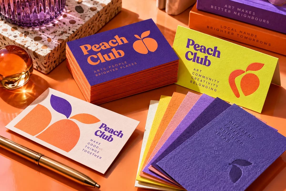 Tactile business cards and paper swatches showing a restrained mix of distinct visual textures and contrasting colors, with orange, electric violet, acid yellow artwork for a fictional community arts club.
